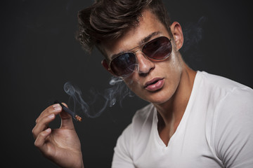  Handsome young man smoking cigarette