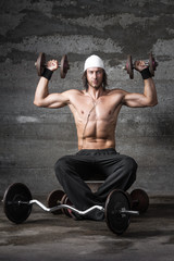 handsome muscular athlete lifting his dumbbells