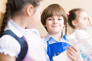 boy draws in class with other children
