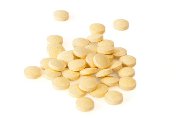 Pile of yellow vitamin pills, isolated on white background