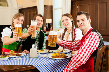 Young People drinking beer in Bavarian restaurant