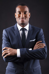 Portrait of a confident young black business man on dark backgro