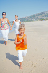 Cute boy with sister and mother on the beach