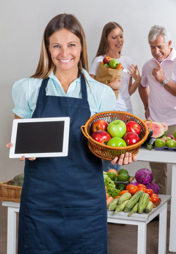 Saleswoman Holding Digital Tablet And Fruits Basket