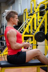 Attractive young man working out on gym equipment
