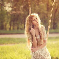 gentle portrait of a beautiful girl on a swing