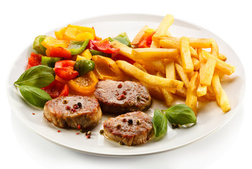 Grilled steaks, French fries and vegetables