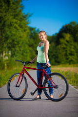 Obraz premium Urban biking - young woman and bike in city