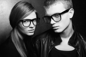 Portrait of gorgeous fashion twins in black trendy glasses