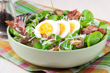 Tasty salad with spinach, bacon, champignon mushrooms, cheese