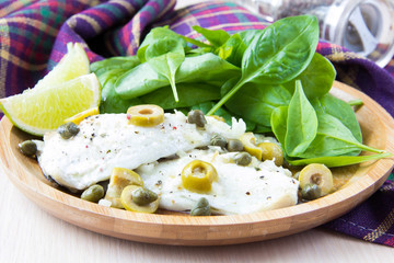 Boiled fillet of white fish Dorado with olives, capers, olive oi