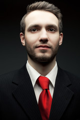 Portrait of a young handsome man (businessman) in black suit