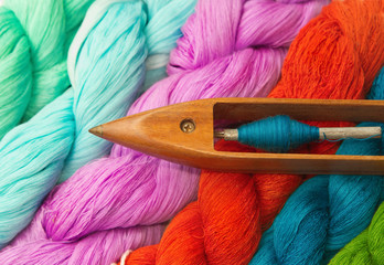 Colorful raw thread and wooden bobbin
