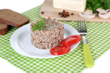 Buckwheat in plate with bread and vegetables closeup