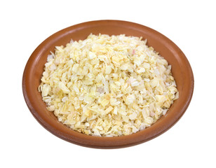 Dried minced onions in a red clay bowl