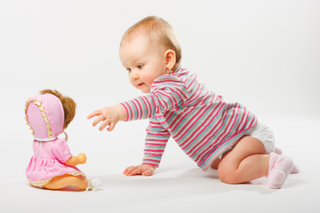 Baby girl playing with doll