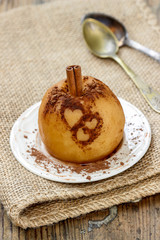 Baked apple decorated with cinnamon heart shape ornament