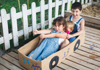 children play in the car out of the box in nature