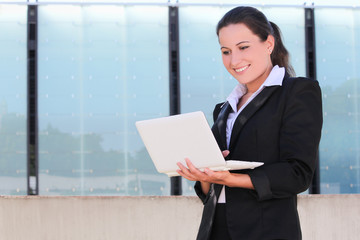 attractive business woman with laptop in the street