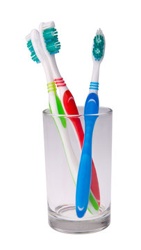 colorful toothbrushes in a glass on background.