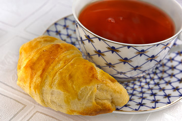 closeup of pile croissants & cup of tea