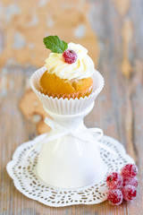 Cupcake with sugared berry and fresh mint leaf