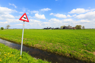 Cow warning sign in a dutch landscape