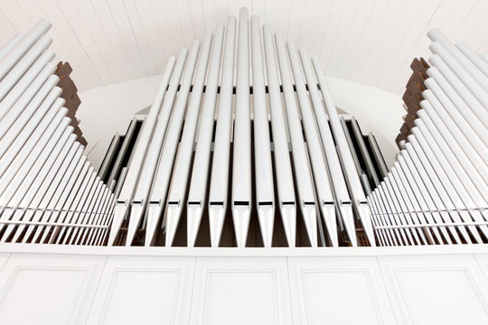 White church organ pipes photographed from below and in symmetry