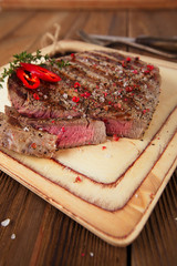 Beef steak on a wooden board and table
