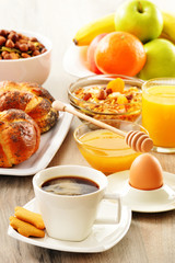 Breakfast including coffee, bread, honey, orange juice, muesli a