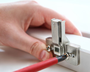 Fixing furniture hinges, using, a Phillips screwdriver.