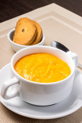 Pumpkin soup in white bowl with crouton