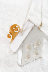 Obraz na płótnie Canvas Gingerbread man and wooden house on a festive Christmas snow