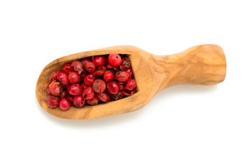 pink peppercorns in a wooden scoop