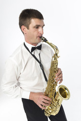 Fototapeta premium Young handsome man plays saxophone