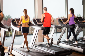 Fototapeta na wymiar People running on treadmills