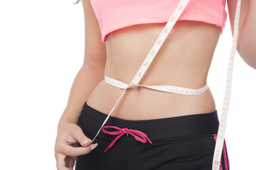 Beautiful woman is measuring her waist