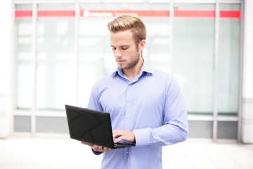 Fototapeta premium Junger Mann mit Laptop