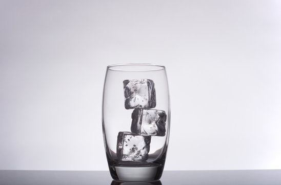 glass with ice cubes on a gradient background