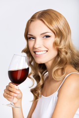 Woman with glass of redwine, on gray