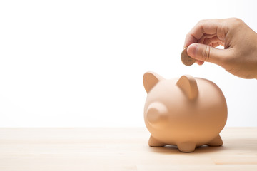 貯金箱にコインを入れる手のアップ