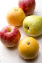 タイルの背景に林檎とグレープフルーツ