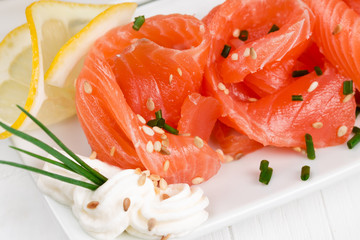 Sliced ​​salmon with  onions on a white plate