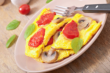 Delicious omelet with tomatoes and mushrooms for breakfast