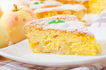 Slice of apple fruit pie on a plate decorated with mint leaf