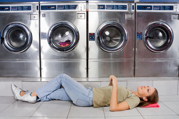 Woman Listening To Music While Lying At Laundry