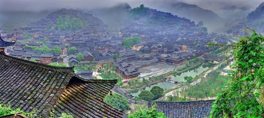 Fototapeten Fog and clouds in  big mountain village in southwest China. © grigvovan