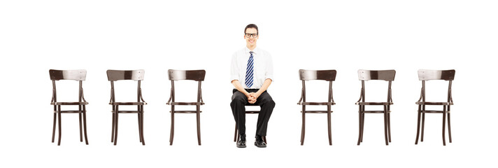 Young male with tie sitting on a chair waiting for job interview