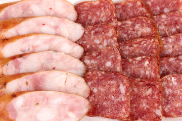 Tasty sliced sausage on plate close-up