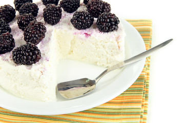 Cheesecake with fresh berries on white plate closeup